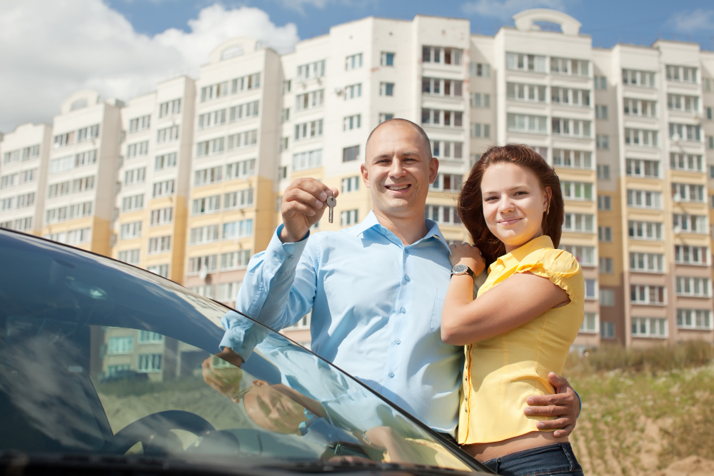 Man and wife holding a key with buildings in the Arizona background